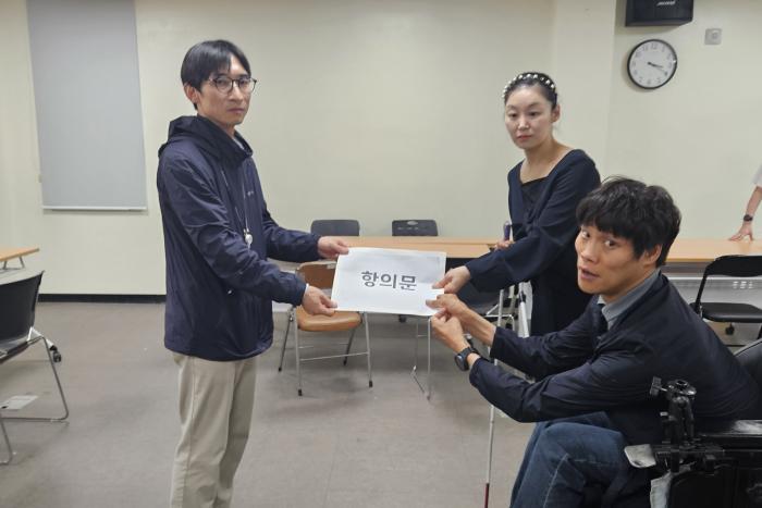 파주시선거관리위원회 김태수 사무국장에게 항의문을 전달하고 있다파주자유로센터 제공