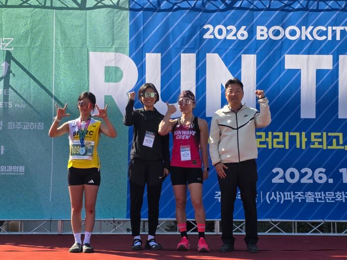 2026 파주북시티아트마라톤 10km 참가자들이 시상 무대에서 파이팅 포즈를 취하며 기념촬영을 하고 있다 하효종 기자